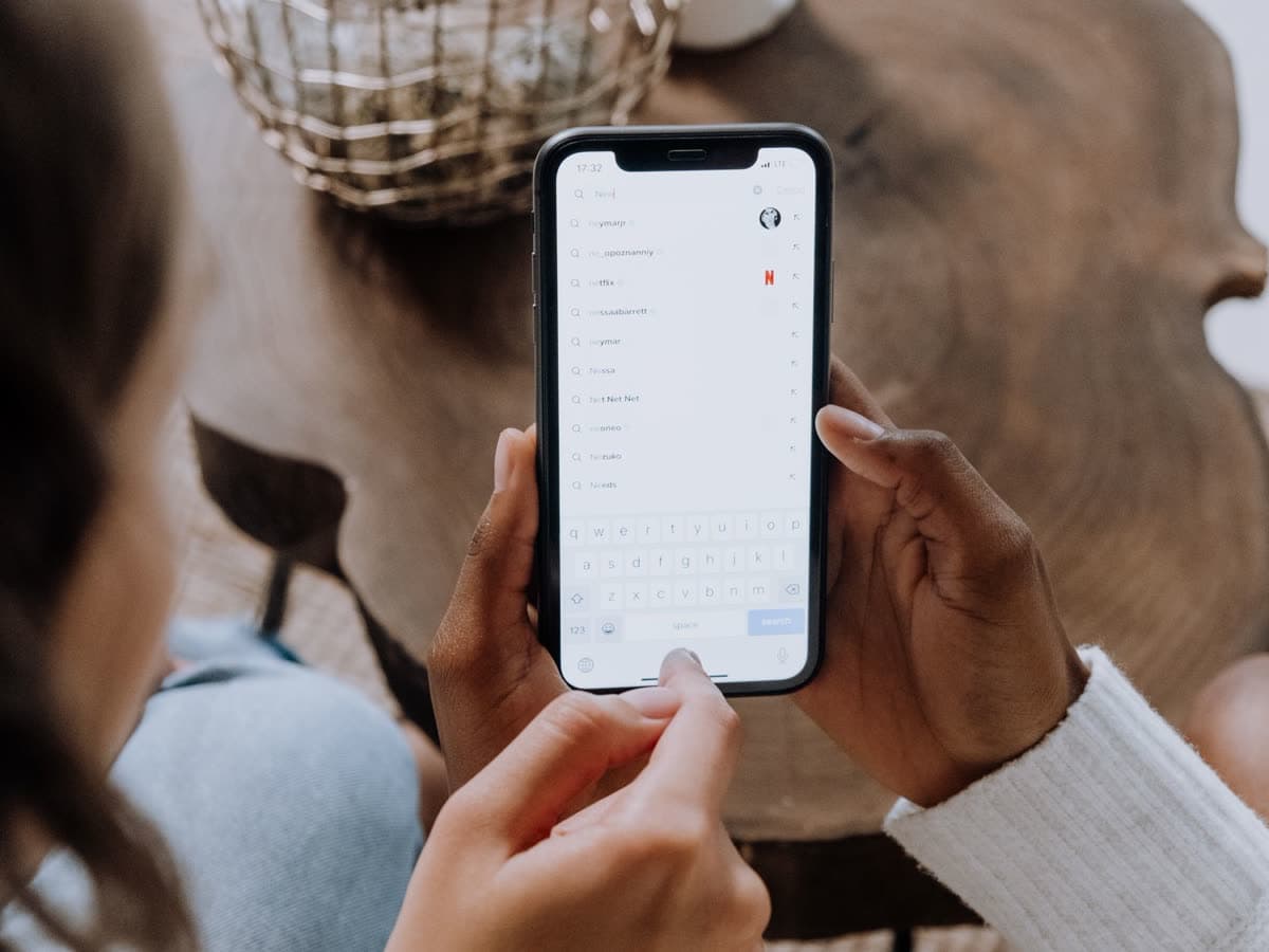 Someone typing a question into their phone.